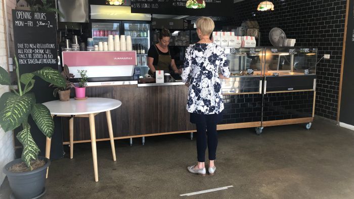 Cafes are adhering to social distancing requirement, places markers on the floor to show people how far apart to stand. (Photo: ABC)