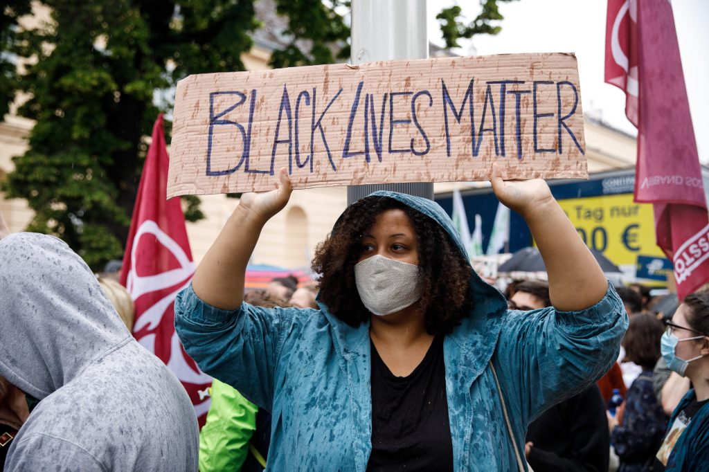 A protester wearing a face mask holds up a placard bearing the slogan 'Black Lives Matter' as she marches during a rally named 'Justice for Black Lives' in Vienna, Austria  EPA/FLORIAN WIESER