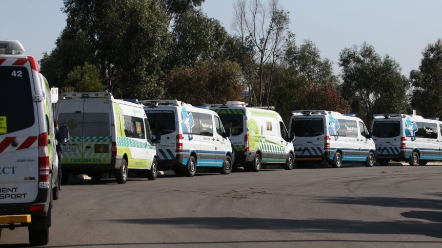 Patient transport vans parked outside Epping Gardens aged care home in Melbourne's north on Wednesday, as authorities prepared to transport several residents infected with coronavirus to hospital. (Photo: ABC News)