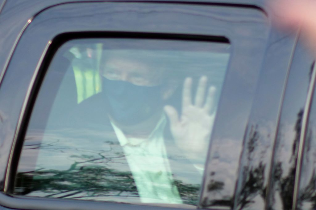 President Donald Trump drives past supporters gathered outside Walter Reed National Military Medical Center in Bethesda, Md., Sunday, Oct. 4, 2020. Trump was admitted to the hospital after contracting COVID-19. (AP Photo/Anthony Peltier)