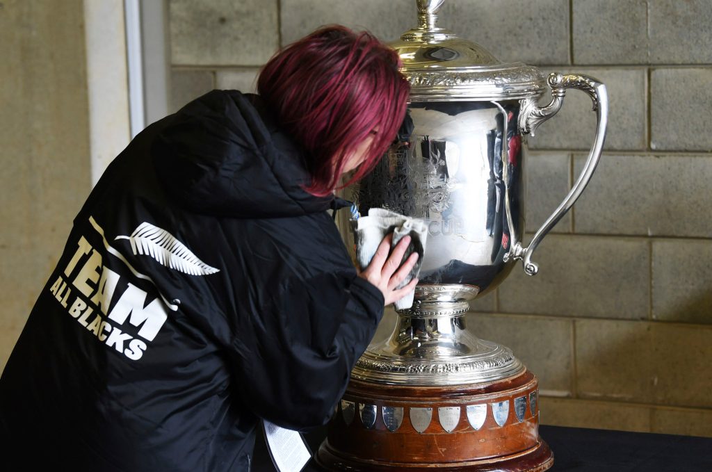 A staff member polishes the Bledisloe Cup ahead of the rugby game between the All Blacks and the Wallabies in Wellington. (Andrew Cornaga/Photosport via AP)