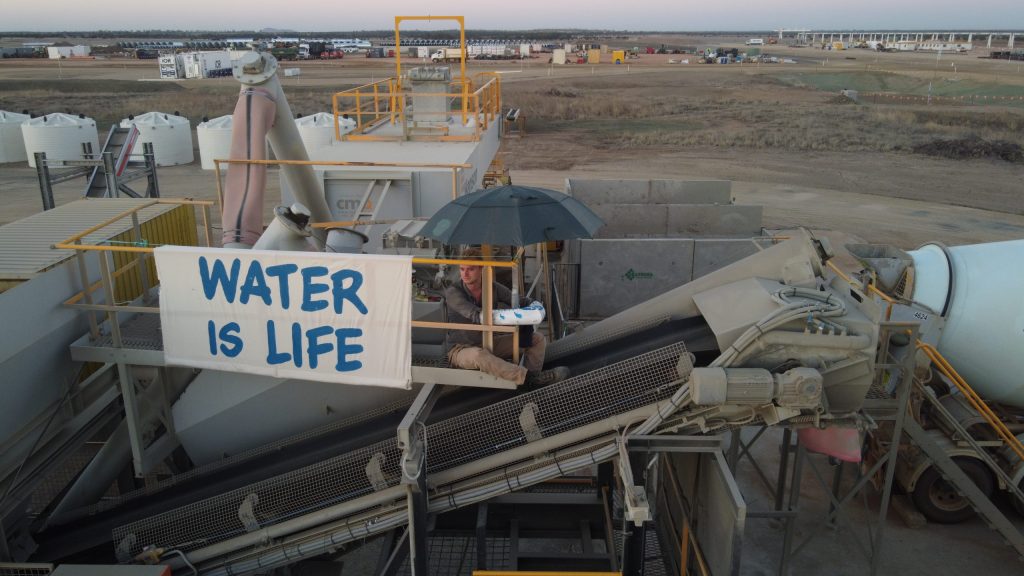 A supplied image shows Magnetic Island resident Barney Jackson staging a protest by attaching himself to a concrete batching plant on an Adani construction site near Belyando. (Photo: AAP Image/Supplied by Frontline Action on Coal)