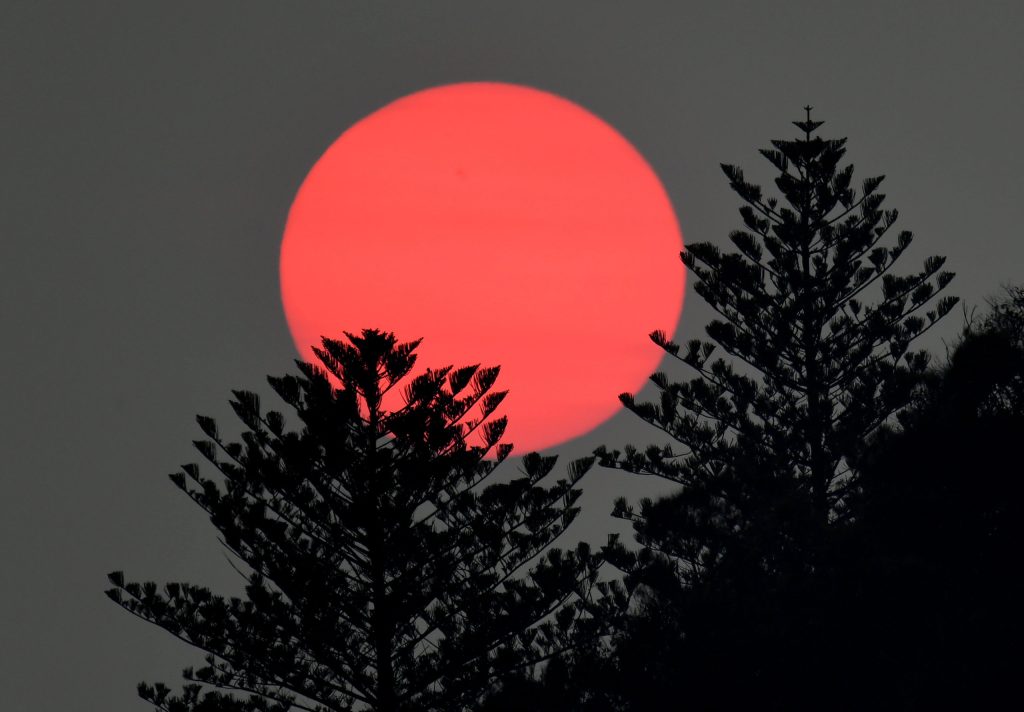 Sunrise is seen through a low band of smoke caused by the Fraser Island bushfires, which have now been burning for more than six weeks. (Photo: AAP Image/Dave Hunt) 