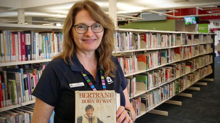 CityLibraries Townsville's Julie Zacchei holds the well-travelled book, which was returned this week — 33 years after being borrowed. Photo: Audience submitted