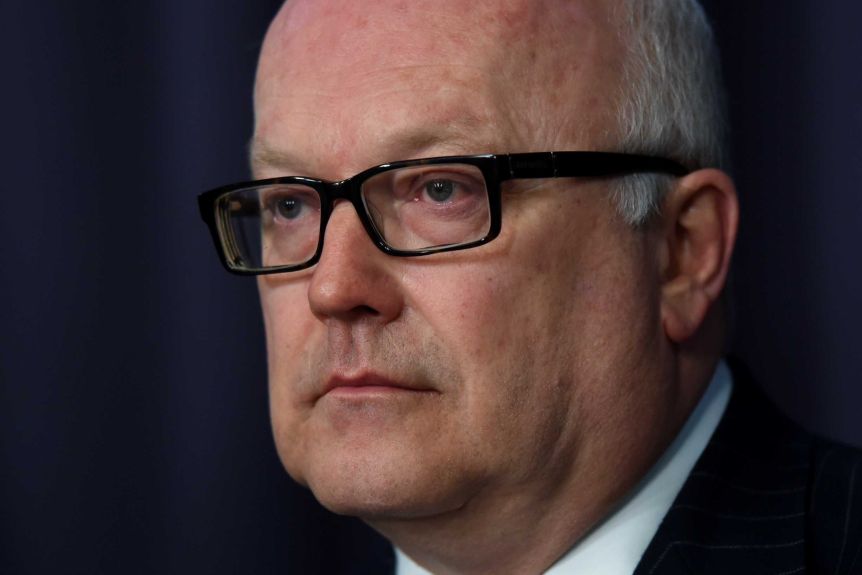 Thumbnail for As Aussies scramble to get home, Brandis under fire for lazy month-long break