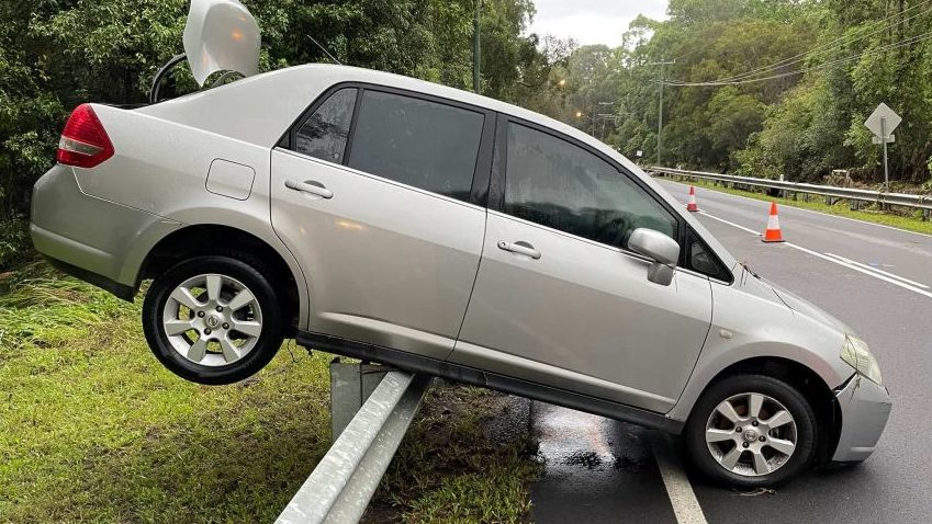 A car was washed onto a guard rail at Thornlands in Brisbane after major flooding impacted southeast Queensland overnight. (Photo: ABC News: Michael Rennie)