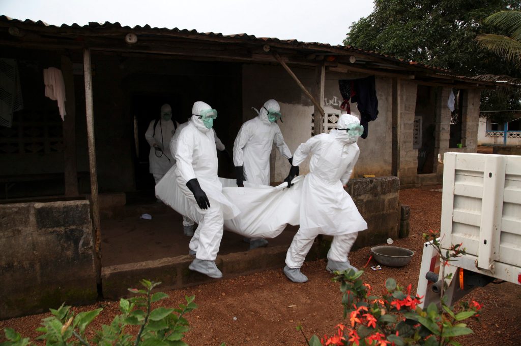 Liberian nurses carry the body of an Ebola victim from a house for burial in the Banjor Community on the outskirts of Monrovia, Liberia, in 2014. (Photo: EPA/AHMED JALLANZO)