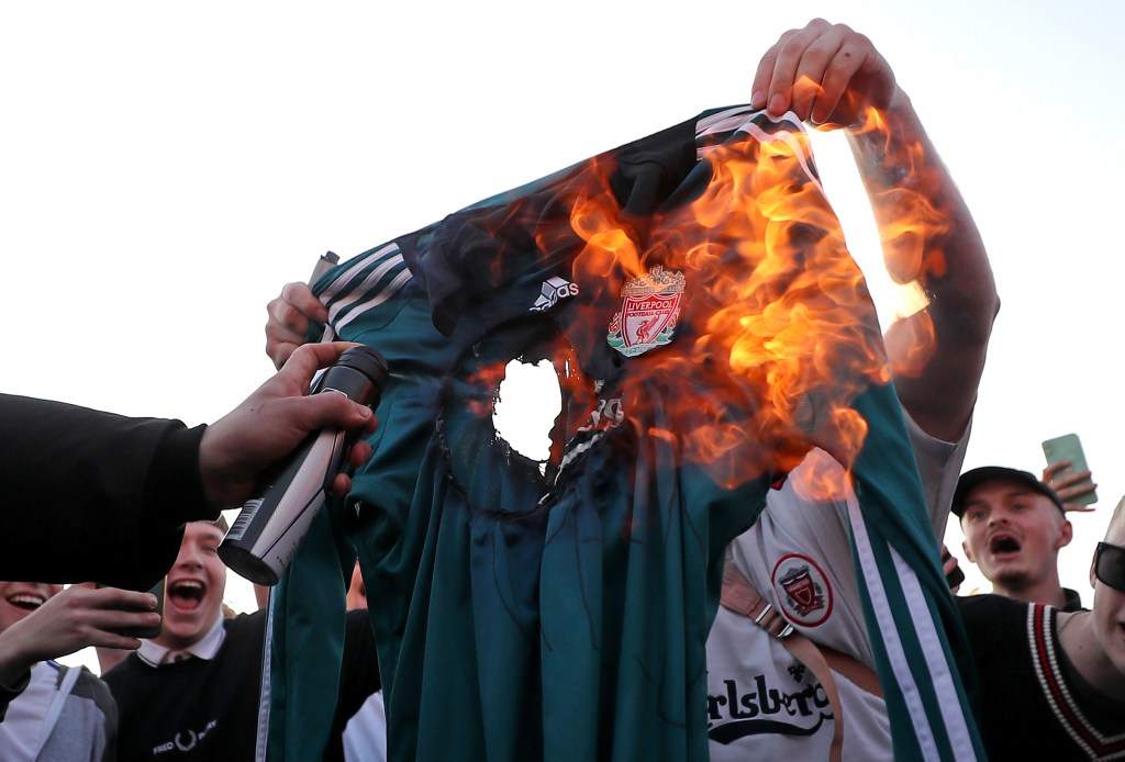 Fans burn a Liverpool replica shirt outside Elland Road against Liverpool's decision to be included amongst the clubs attempting to form a new European Super League. ( Zac Goodwin/PA Wire.)