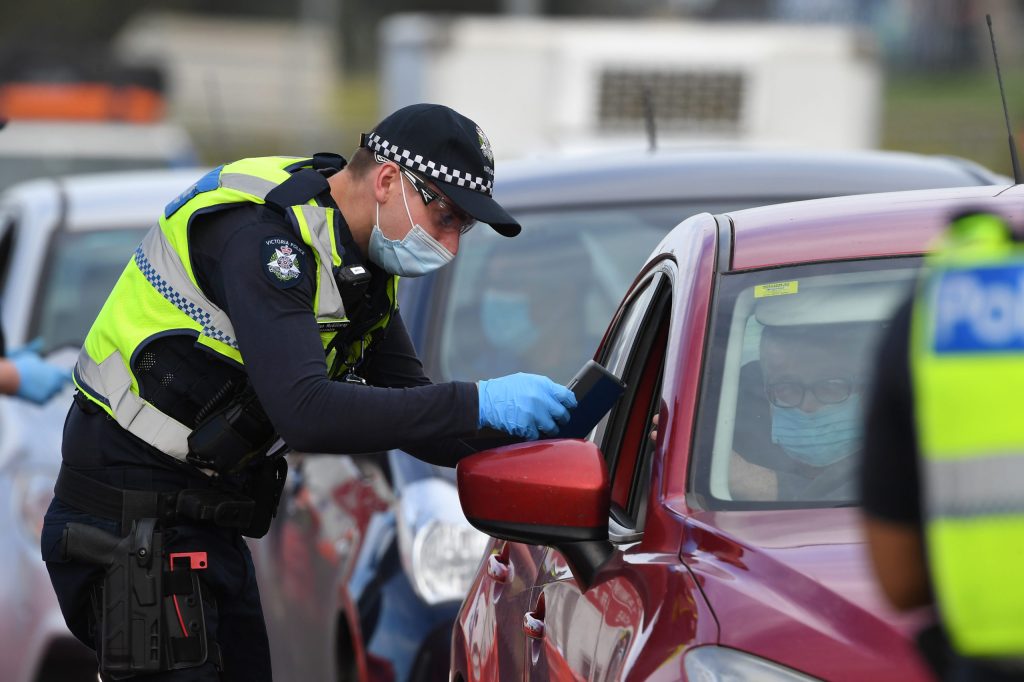 Victoria Police are seen at work at a roadside checkpoint near Donnybrookin September last year. Victoria Police may bring back a "ring of steel" increasing efforts at city checkpoints (AAP Image/James Ross)