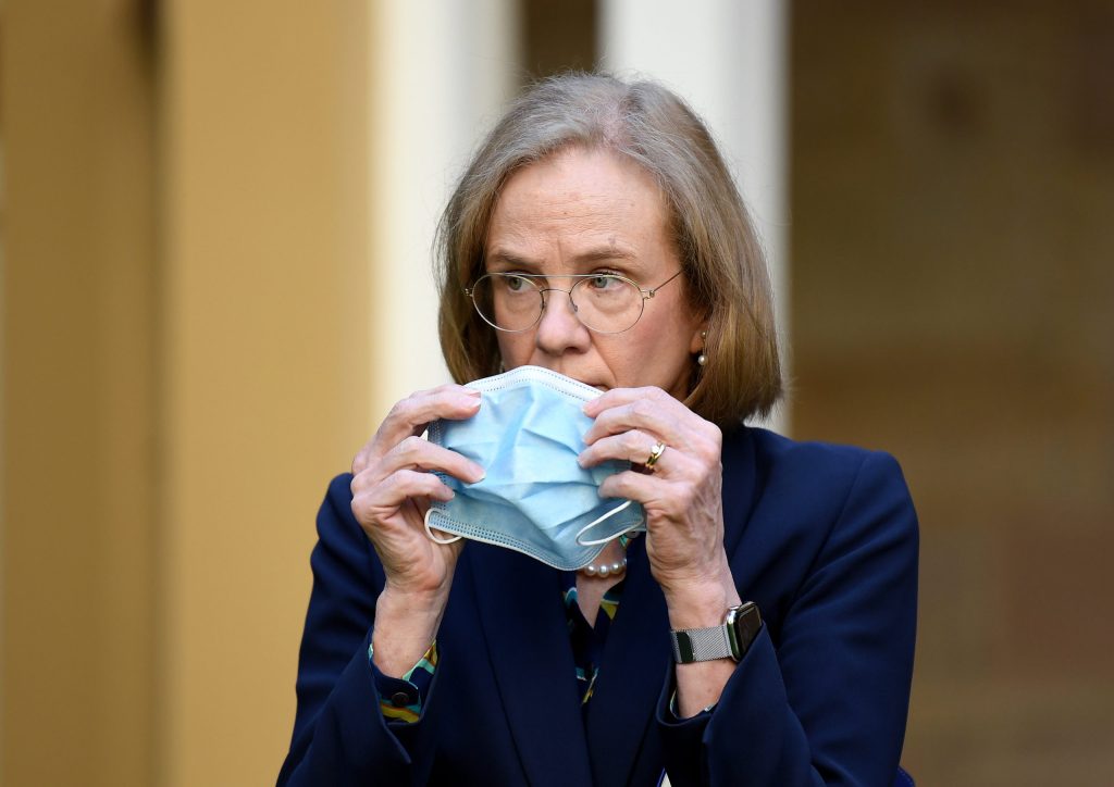 Queensland Chief Health Officer Dr Jeannette Young puts her mask on during a press conference. (AAP Image/Dan Peled) 
