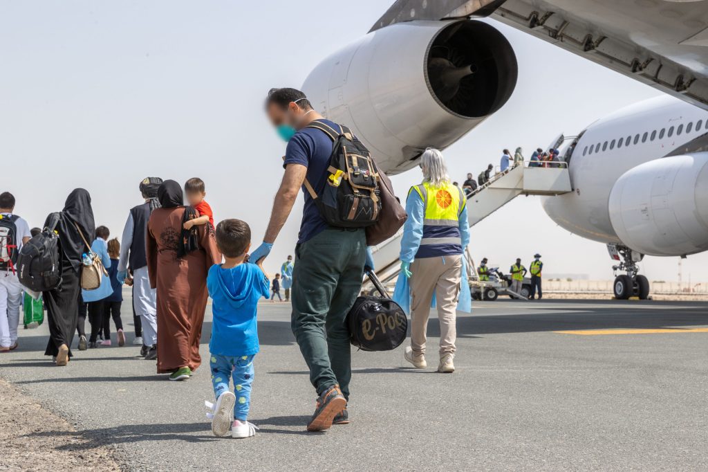 Afghanistan evacuees board a flight to Australia from the Australian Defence Force's main operating base in the Middle East region. (AAP Image/Supplied by Australian Defence Force) 