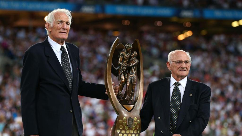 Norm Provan and Arthur Summons hold the NRL trophy, designed on a photograph of the pair.