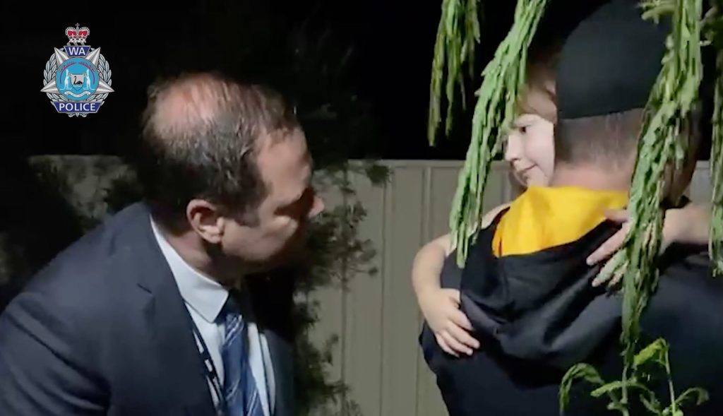 A screen grab taken from body-worn camera footage obtained on Wednesday of foour-year-old Cleo Smith being rescued by WA Police including Senior Sergeant Cameron Blaine. WA police officers discovered Cleo  alone in a bed in the house in Carnarvon, 75 kilometres south from where she went missing and just minutes from her family home. (AAP Image/Supplied by WA POLICE) 
