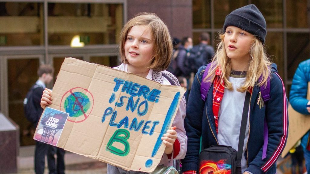 Two children join the march with one holding a placard reading "There is no  planet B" during a rally outside the UN Climate Change Conference in Glasgow. (Photo by Iain McGuinness / SOPA Images/Sipa USA)