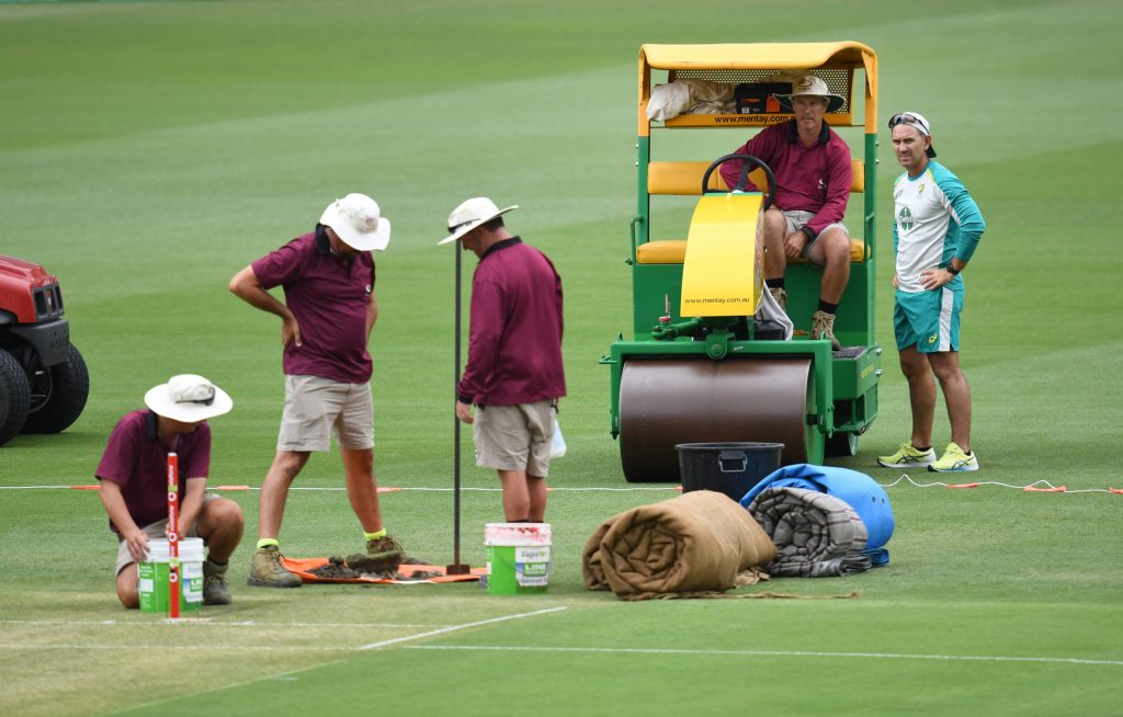 Australian coach Justin Langer (right)] is seen talking to Gabba head curator David Sandurski (2nd from right) during preparations for the First Ashes Test at the Gabba on Wednesday . (AAP Image/Darren England) 
