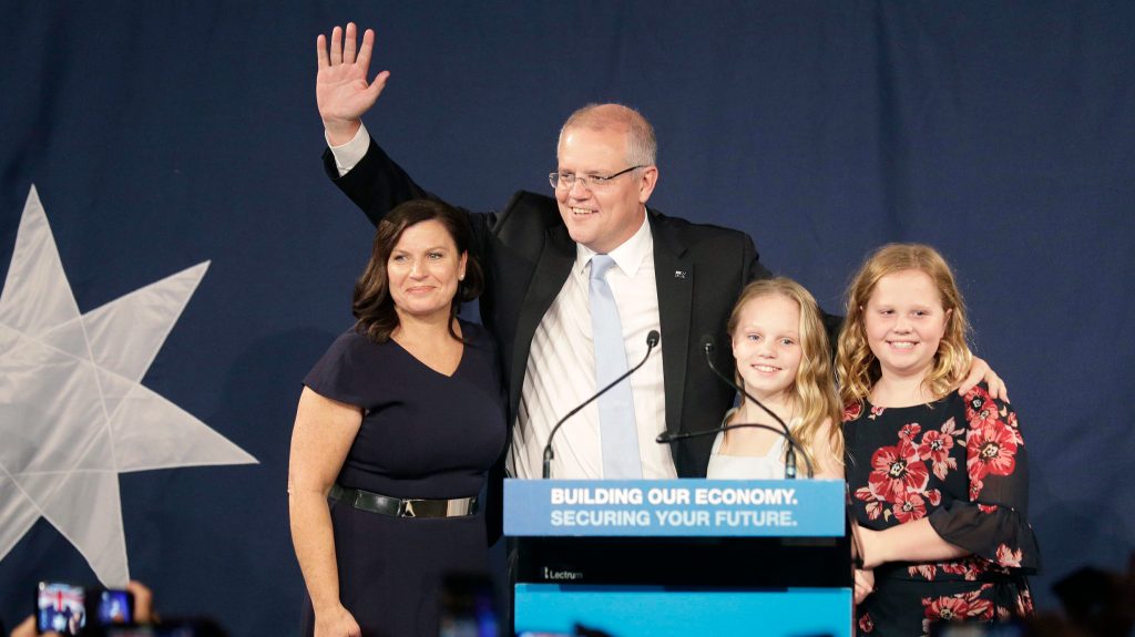 Australian Prime Minister Scott Morrison arrives on stage to speak to party supporters flanked by his wife, Jenny, left, and daughters Lily, and Abbey, right, after his opponent concedes in the federal election on May 19, 2019. (AP Photo/Rick Rycroft)