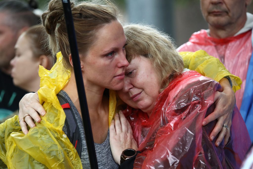 Two people embrace during a rally against the war in Ukraine at King George Square in Brisbane, Friday, February 25, 2022. (AAP Image/Jono Searle) 