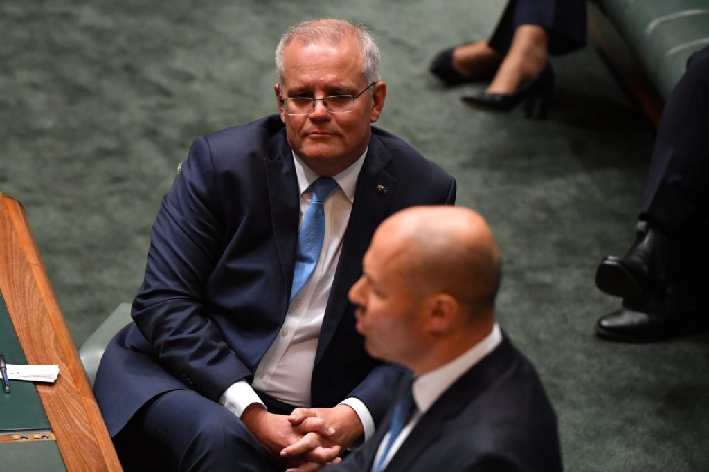 Prime Minister Scott Morrison looks on as Treasurer Josh Frydenberg hands down his fourth budget. (AAP Image/Mick Tsikas)