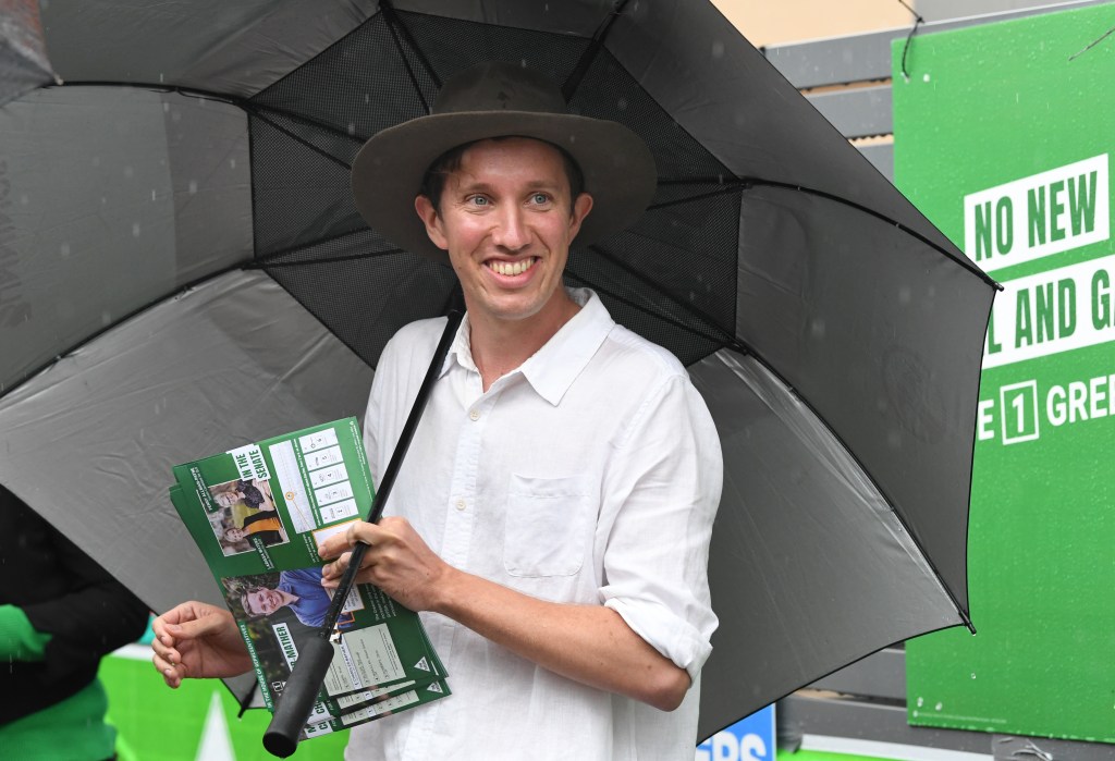 Max Chandler-Mather, Greens candidate in the seat of Griffith is seen handing out how to vote leaflets at the Brisbane State High polling booth on Federal Election day in Brisbane. (AAP Image/Darren England) 