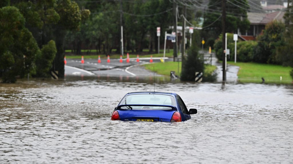 An abandoned car in floodwaters in Lansvale in Western Sydney. (AAP Image/Mick Tsikas) 