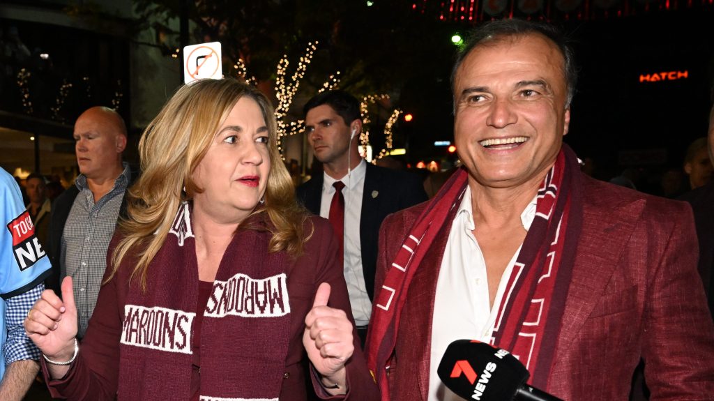  Premier Annastacia Palaszczuk (centre) and her partner Dr Reza Adib (right) walk down Caxton Street before Game 3 of the 2022 State of Origin series between the New South Wales Blues and the Queensland Maroons at Suncorp Stadium.  (AAP Image/Darren England)