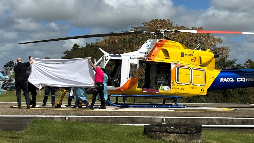 One seriously wounded victim is unloaded from the RACQ CQ Rescue chopper at Mackay Hospital. (ABC News).