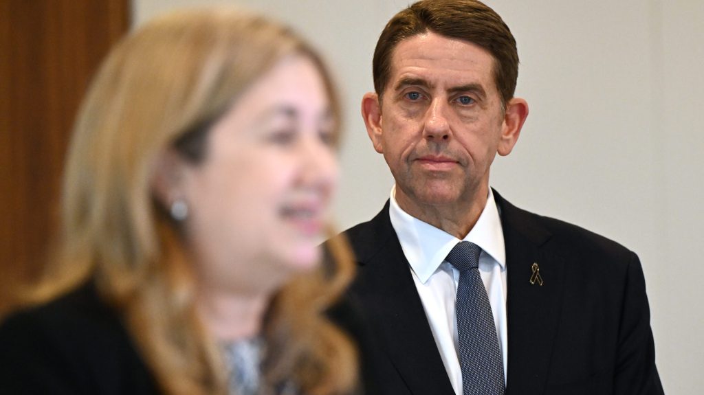 Queensland Treasurer Cameron Dick (right) looks on as Premier Annastacia Palaszczuk (left) addresses a press conference .  (AAP Image/Darren England