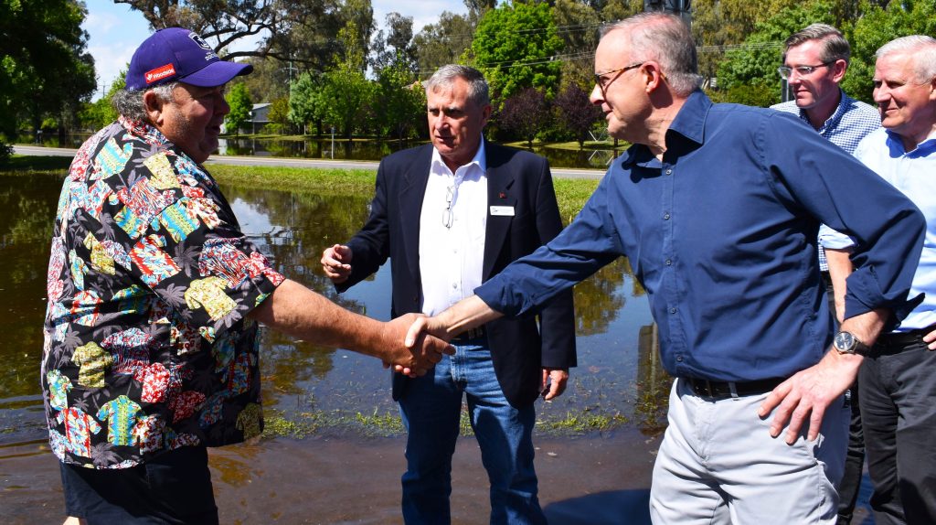 Forbes resident Grahame Ruge greets Australian Prime Minister Anthony Albanese (centre) and New South Wales Premier Dominic Perrottet (second right) during a tour to flood affected areas in Forbes, in the Central West region of New South Wales. (AAP Image/Murray McCloskey) 