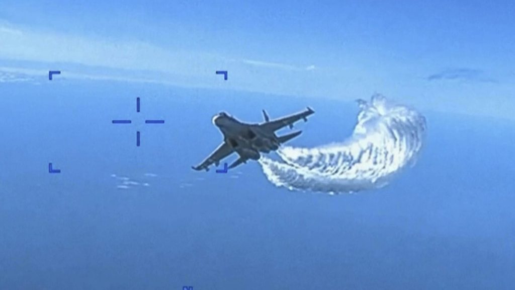 This photo released on Thursday shows a Russian Su-27 approaching the back of the MQ-9 drone and beginning to release fuel as it passes, over the Black Sea, the Pentagon said. (US Department of Defense via AP)