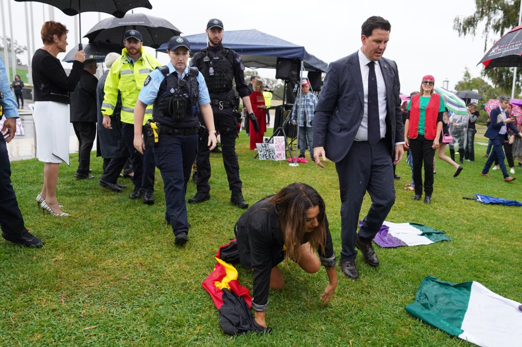 Independent Senator Lidia Thorpe crawls away after attempting to disrupt British anti-transgender rights activist Kellie-Jay Keen-Minshull. (AAP Image/Michelle Haywood) 