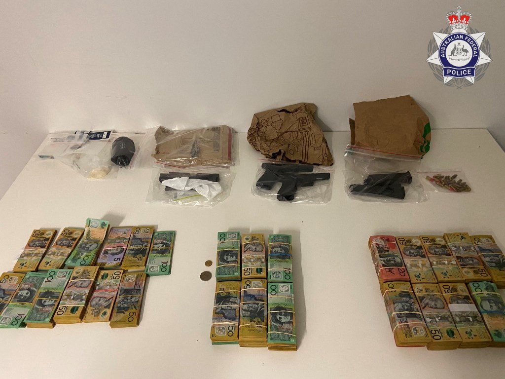 A supplied undated image obtained Friday, April 28, 2023 shows two handguns, ammunition, $370,000 cash and methamphetamine seized by the Australian Federal Police in Brisbane. An alleged bikie stands accused of trying to hide  the items before running from airport security. (AAP Image/Supplied by the Australian Federal Police) 