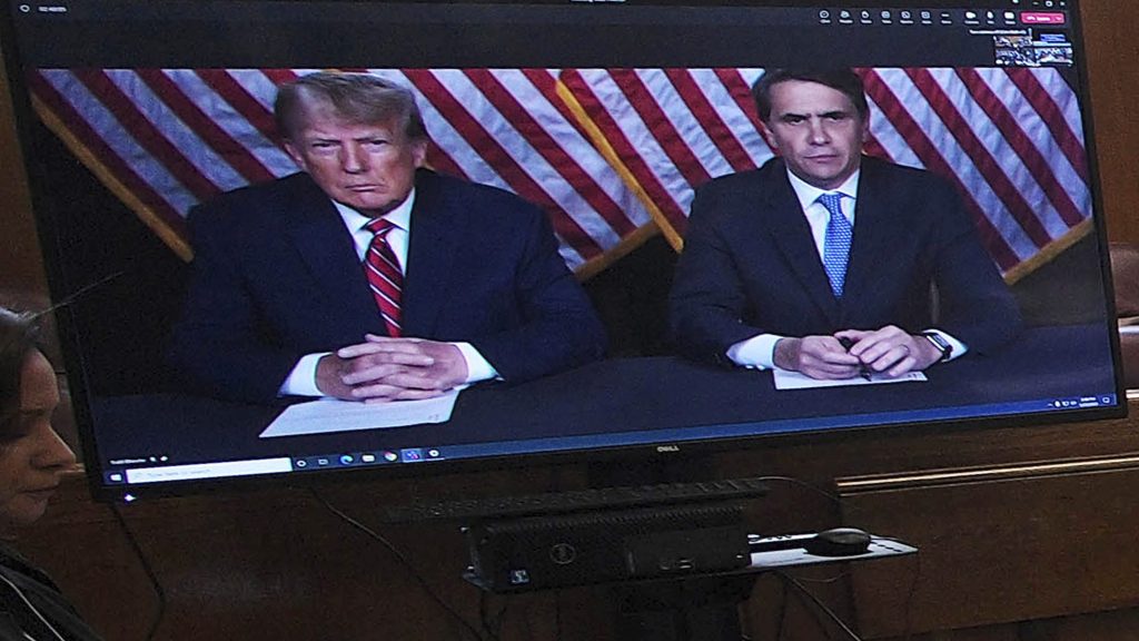 Former president Donald Trump, left on screen, and his attorney, Todd Blanche, right, appear by video before a hearing begins in Manhattan criminal court, in New York The judge set a trial date for late March of next year. (AP Photo/Curtis Means via Pool)