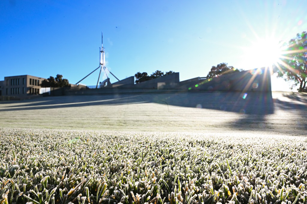Early morning frost is seen on the lawns outside Parliament House, in Canberra, Tuesday, June 20, 2023. (AAP Image/Lukas Coch) NO ARCHIVING