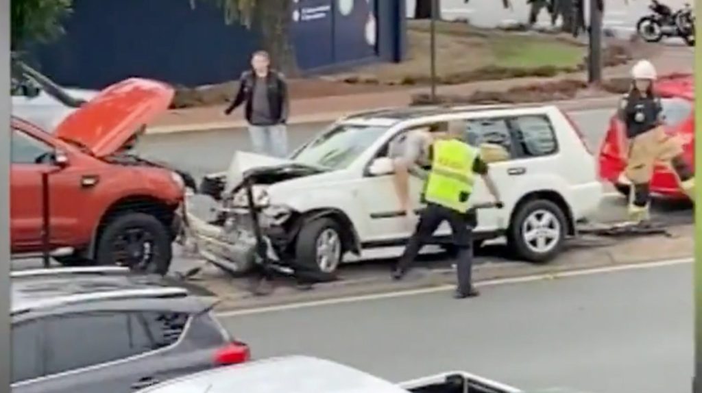 A still image taken from video and obtained on Friday, June 23, 2023, shows a Queensland Police officer striking a man following a three-car crash in Brisbane's north. (AAP Image/Supplied, Nine News) 