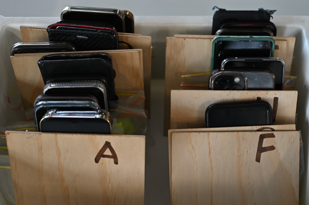 Phones belonging to students are stored in a container after being ‘checked-in’ at Condell Park High School, Monday, April 03, 2023. NSW high schools will begin discussing ways to enforce a state-wide mobile phone ban to soon come into effect to improve children's learning outcomes. (AAP Image/Steven Saphore) NO ARCHIVING