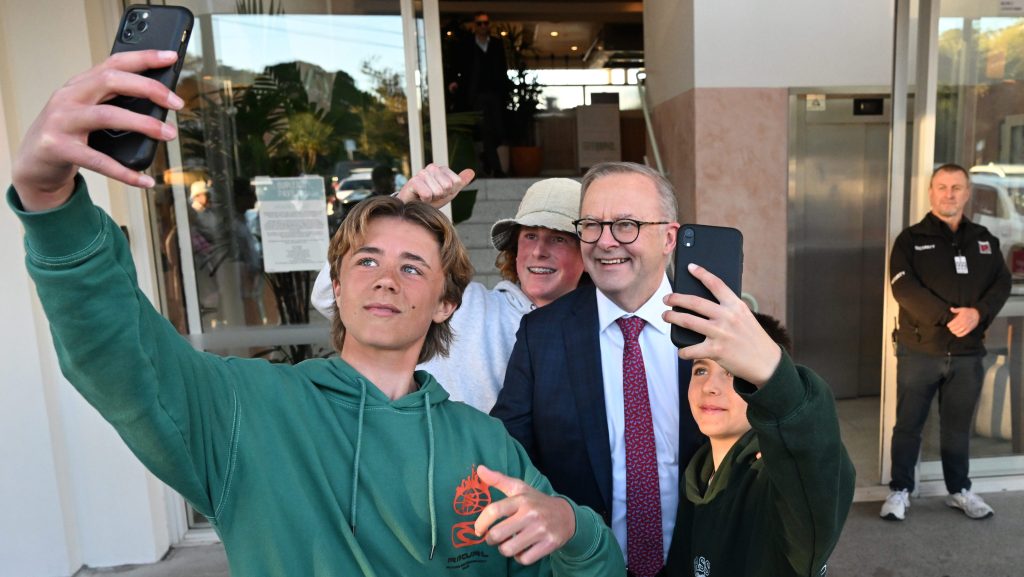 Australian Prime Minister Anthony Albanese takes a selfie with people at Burleigh Heads on the Gold Coast, Tuesday, June 27, 2023. Prime Minister Albanese is campaigning on the Gold Coast ahead of the Fadden by-election. (AAP Image/Darren England) 