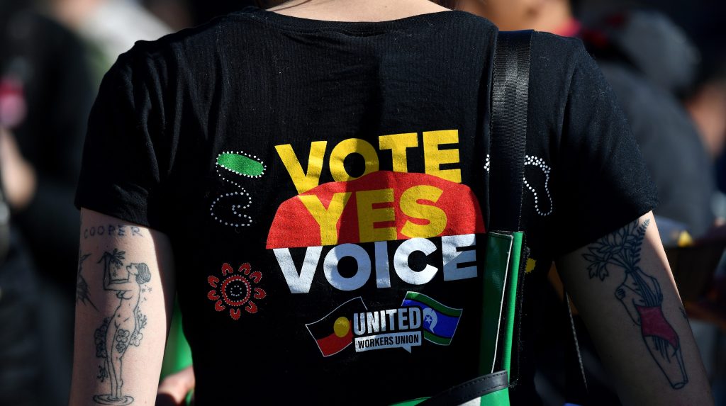 Supporters wear merchandise in support of a yes vote during a Yes 23 community event in support of an Indigenous Voice to Parliament, in Sydney, Sunday, July 2, 2023. (AAP Image/Bianca De Marchi)