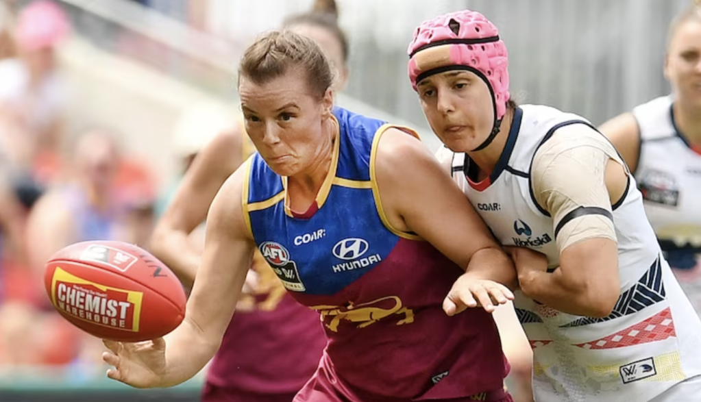 Heather Anderson (right) played for the Adelaide Crows and was known for wearing a bright pink helmet during her matches.(AAP: Dan Peled)