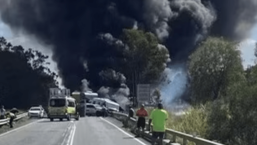 Plumes of smoke pour from the scene of a four-vehicle pile-up near Rockhampton, leaving the highway closed and six people in hospital. (QAS supplied)