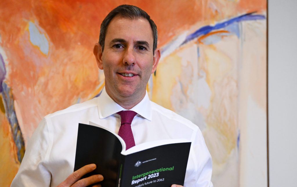 Australian Treasurer Jim Chalmers poses for photographs holding a copy of the Intergenerational Report 2023 at Parliament House in Canberra, Thursday, August 24, 2023. (AAP Image/Lukas Coch) 