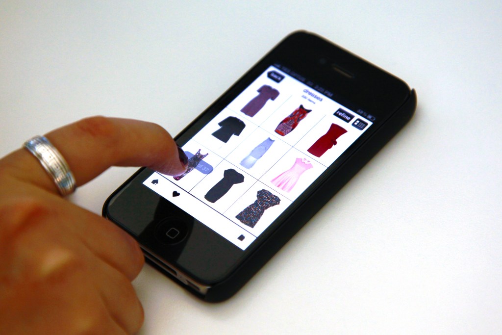 A woman browses an online clothing store on her iPhone, Sydney, Tuesday, Aug. 21, 2012. (AAP Image/Stephanie Flack) NO ARCHIVING