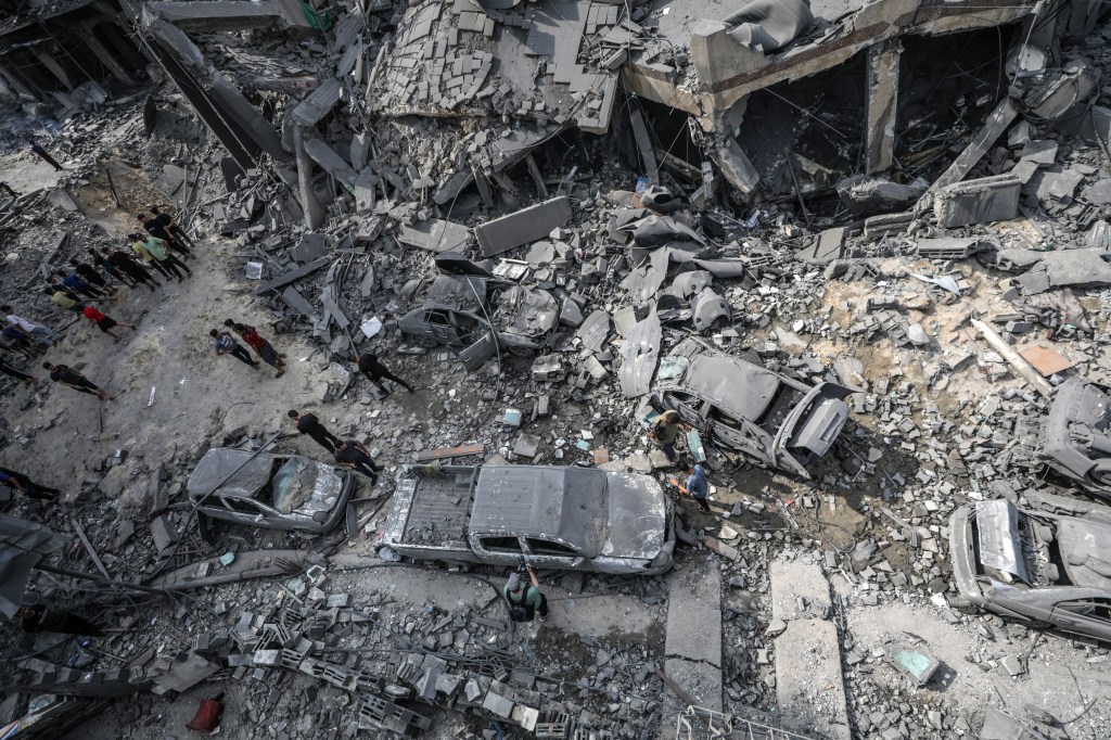 epa10909357 Palestinians inspect damaged cars, amid the rubble of a destroyed area, after Israeli air strikes in Gaza City, 09 October 2023. The Israeli army announced on 09 October, it carried out over 500 strikes on targets across the Gaza Strip overnight. Palestinian officials said almost 500 people were killed and over 2,700 were injured after Israel launched retaliatory raids and air strikes. An unprecedented attack on southern Israel on 07 October claimed by the Islamist movement Hamas killed more than 700 Israelis and left over 2,150 injured, the Israeli army said. EPA/MOHAMMED SABER