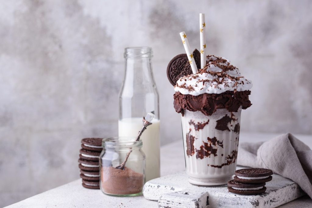 Sweet milkshake with chocolate cookies and whipped cream