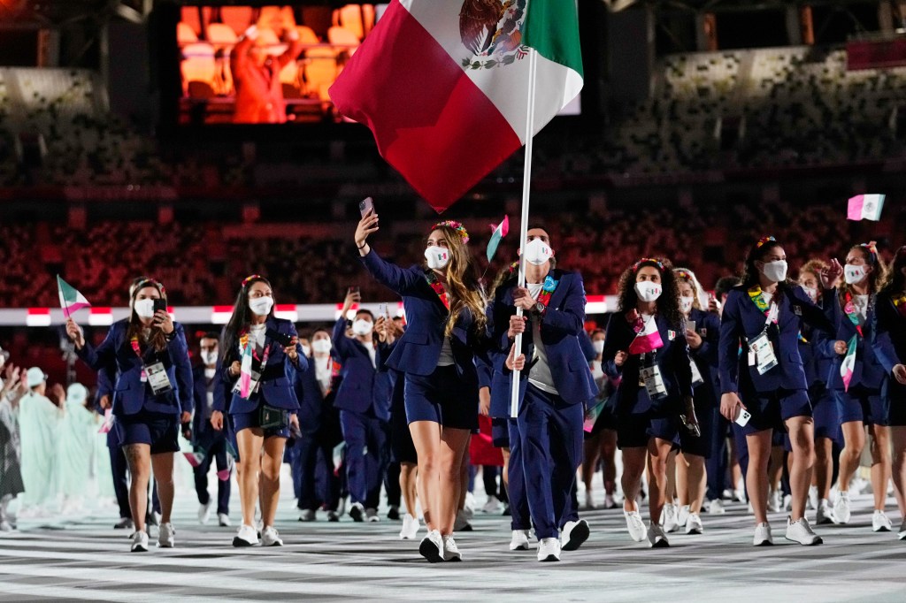 Gaby Lopez and Rommel Pacheco Marrufo, of Mexico, carry their country's flag during the opening ceremony in the Olympic Stadium at the 2020 Summer Olympics, Friday, July 23, 2021, in Tokyo, Japan. (AP Photo/Petr David Josek)