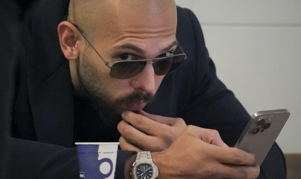 Andrew Tate checks his mobile phone inside the Court of Appeal building in Bucharest, Romania, Friday, Dec. 22, 2023. (AP Photo/Vadim Ghirda)