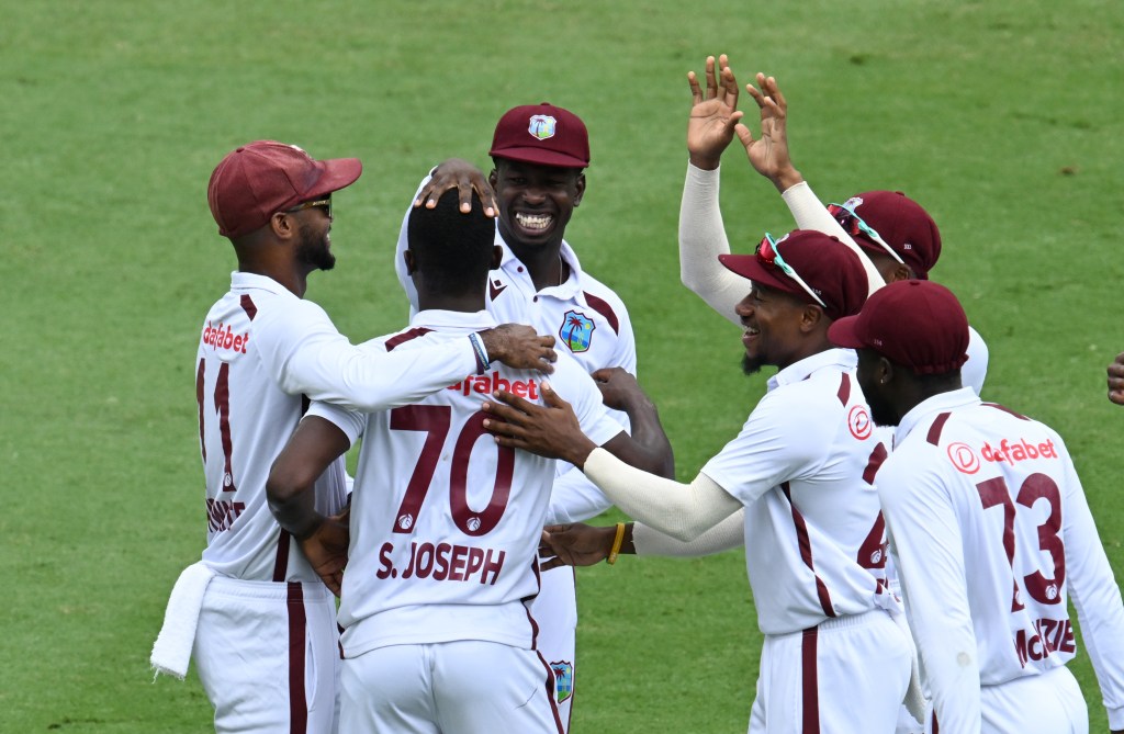 Man of the hour Shamar Joseph (centre) of the West Indies celebrates with team mates after getting the wicket of Travis Head of Australia on Day 4 of the Second Test between Australia and the West Indies at the Gabba in Brisbane, Sunday, January 28, 2024. (AAP Image/Darren England) NO