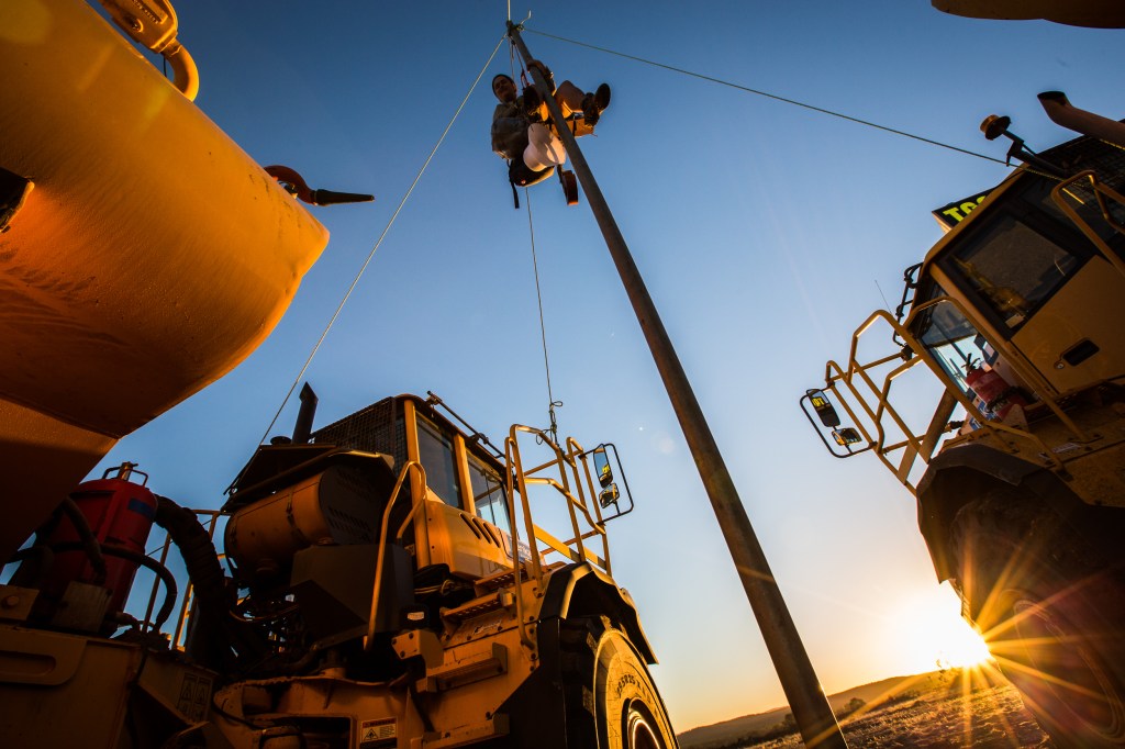 A protester attached to machinery at Whitehaven Coal's $767 million Maules Creek project, near Boggabri in northwest NSW. (AAP Image/Leard Forest Alliance) 