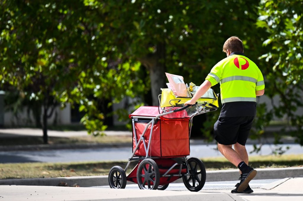 Mail is delivered by an Australia Post employee in Canberra, Thursday, March 2, 2023. (AAP Image/Lukas Coch) NO ARCHIVING