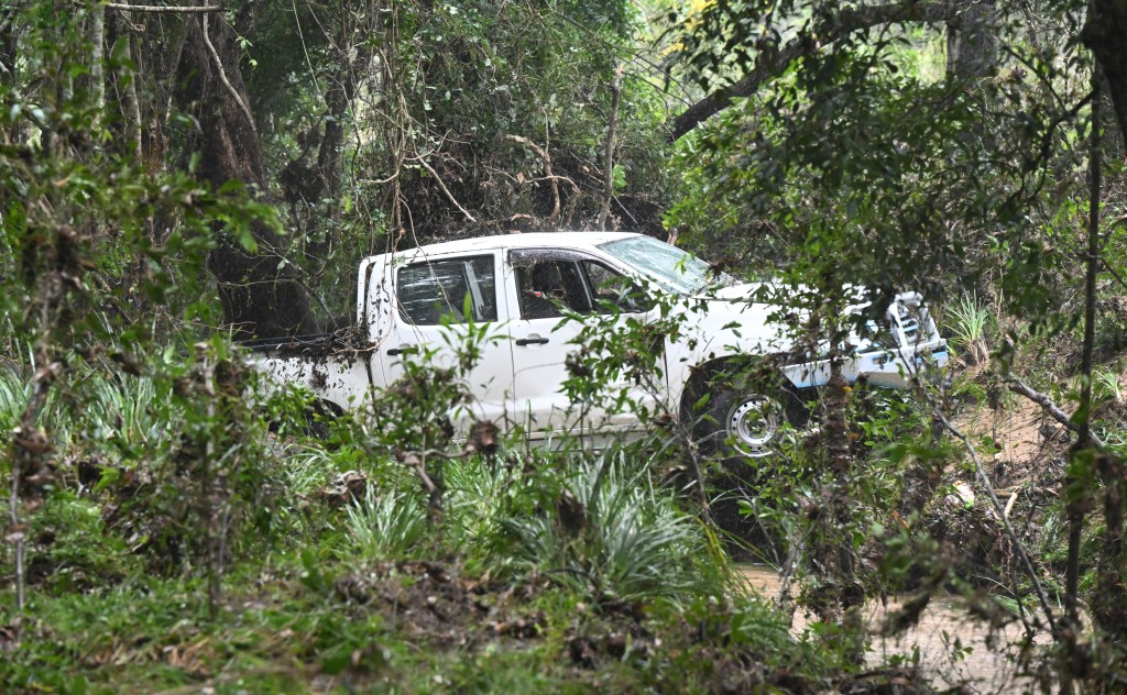 A car is seen after being washed away by floodwaters into a creek where a man has been found dead in Greenbank, south-west of Brisbane, Thursday, April 4, 2024. A man has died in floodwaters in Queensland's southeast as the state braces for more heavy rain, with NSW also expecting a drenching. (AAP Image/Darren England) NO ARCHIVING