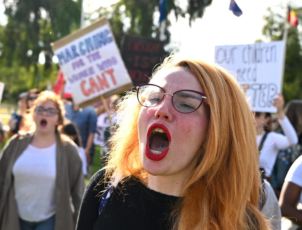 A woman attends a rally to a call for action to end violence against women, in Canberra, Sunday, April 28, 2024. (AAP Image/Lukas Coch) 
